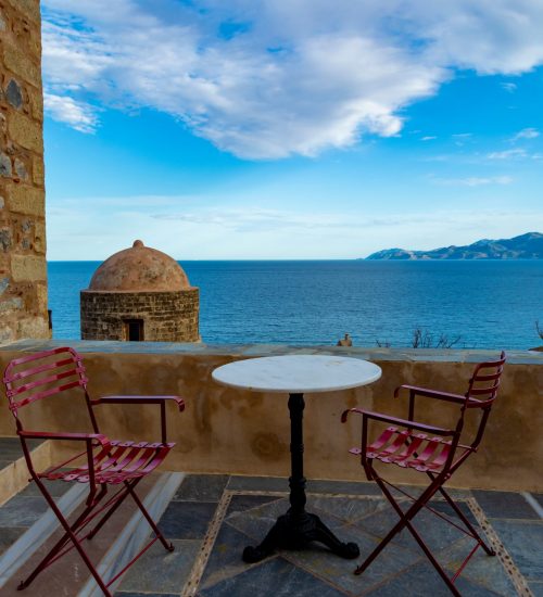 Greek cafe or tavern with small tables on outside terrace with nice view