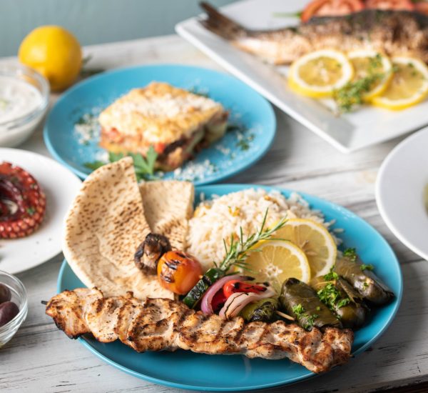 assorted popular greek plates on rustic wooden background